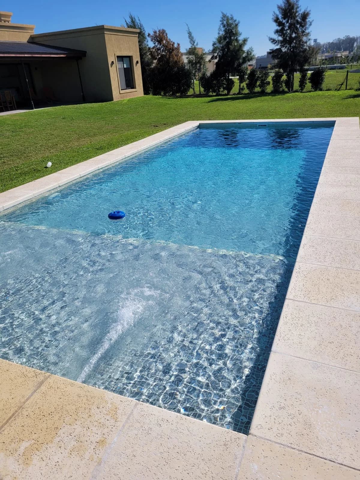 Piscina moderna con tumbonas y paisajismo